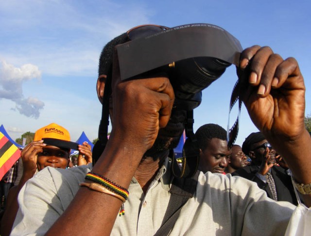 Man photographing solar eclipse, Uganda