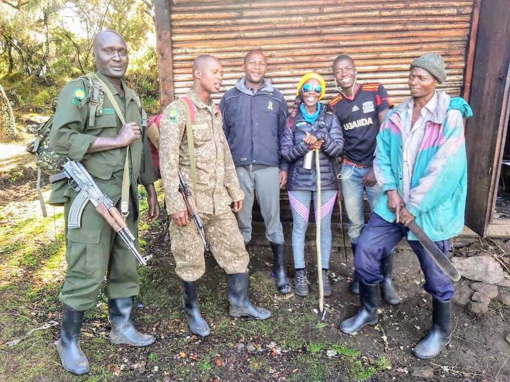 Jean Byamugisha preparing to hike Mount Elgon, Uganda, accompanied by porters and Uganda Wildlife Authority rangers