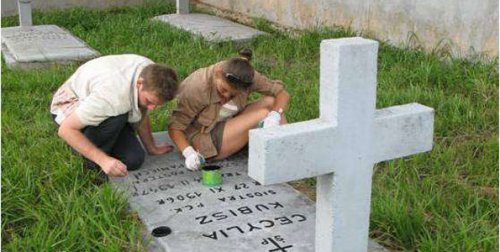 Relatives of Polish exiles refresh tombstone. Polish Church. PHOTO Uganda National Archives